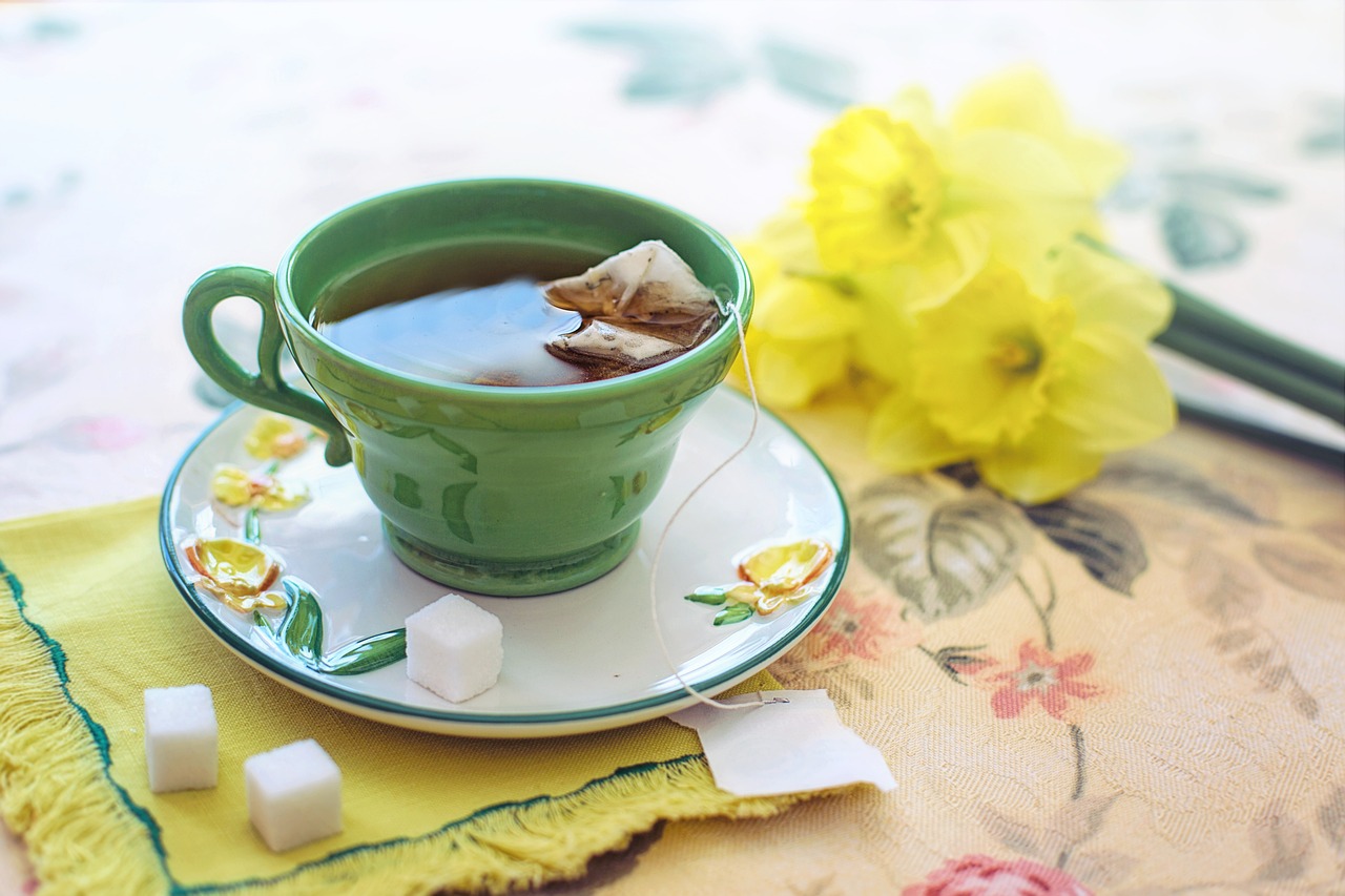 tea cup on a bright napkin with flowers in the background